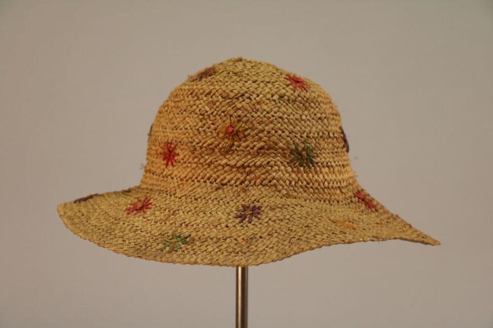 Hoed in gevlochten stro met bloemen in veelkleurige raffia