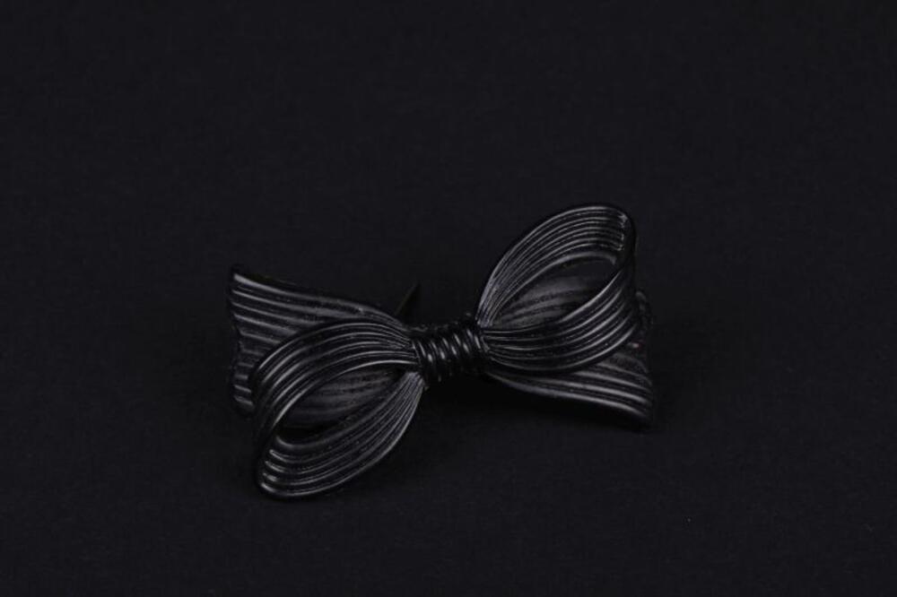 Broche in zwarte plastic in strikvorm