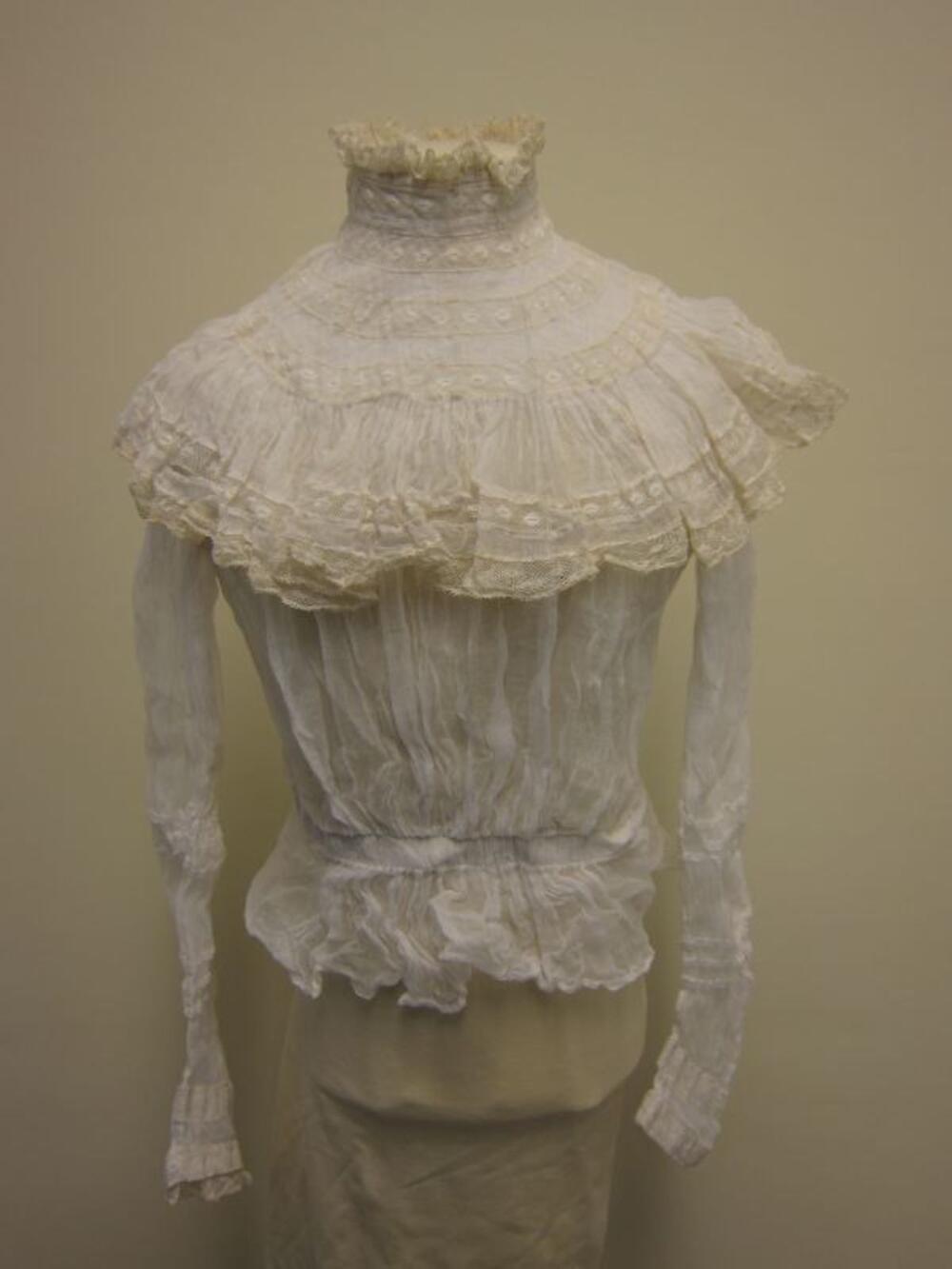 Communieensemble in witte batist bestaande uit rok, blouse, halsboord, communiebeurs en…