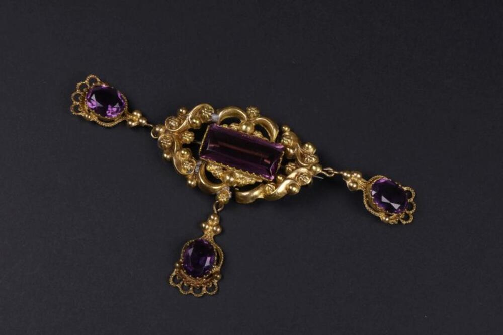 Broche in metaal met drie violetkleurige stenen