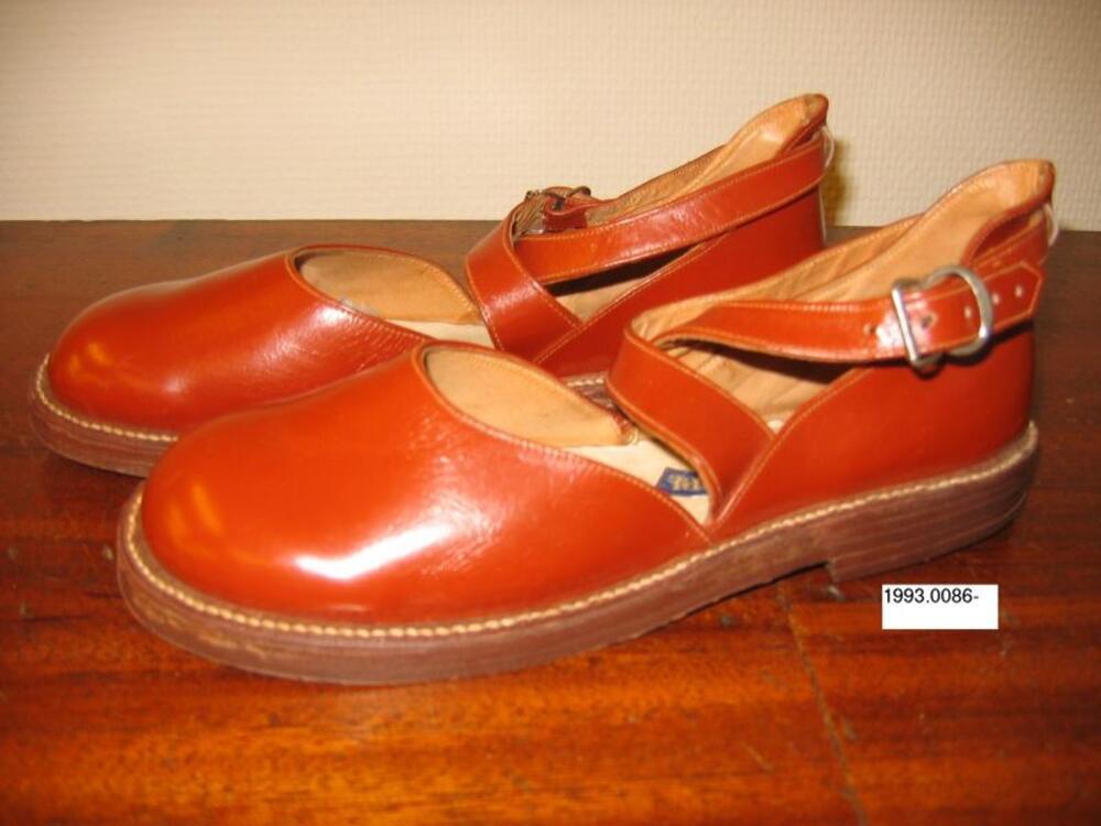 Schoenen in roestbruin leer met gekruiste riemen over de wreef