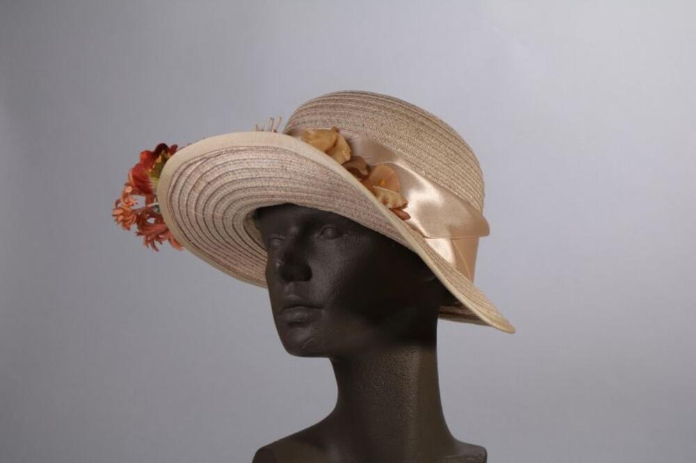 Hoed in beige stro versierd met beige lint en boeket