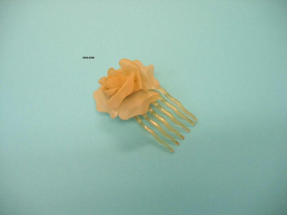 Haarkam in gele plastic met bloemdecoratie