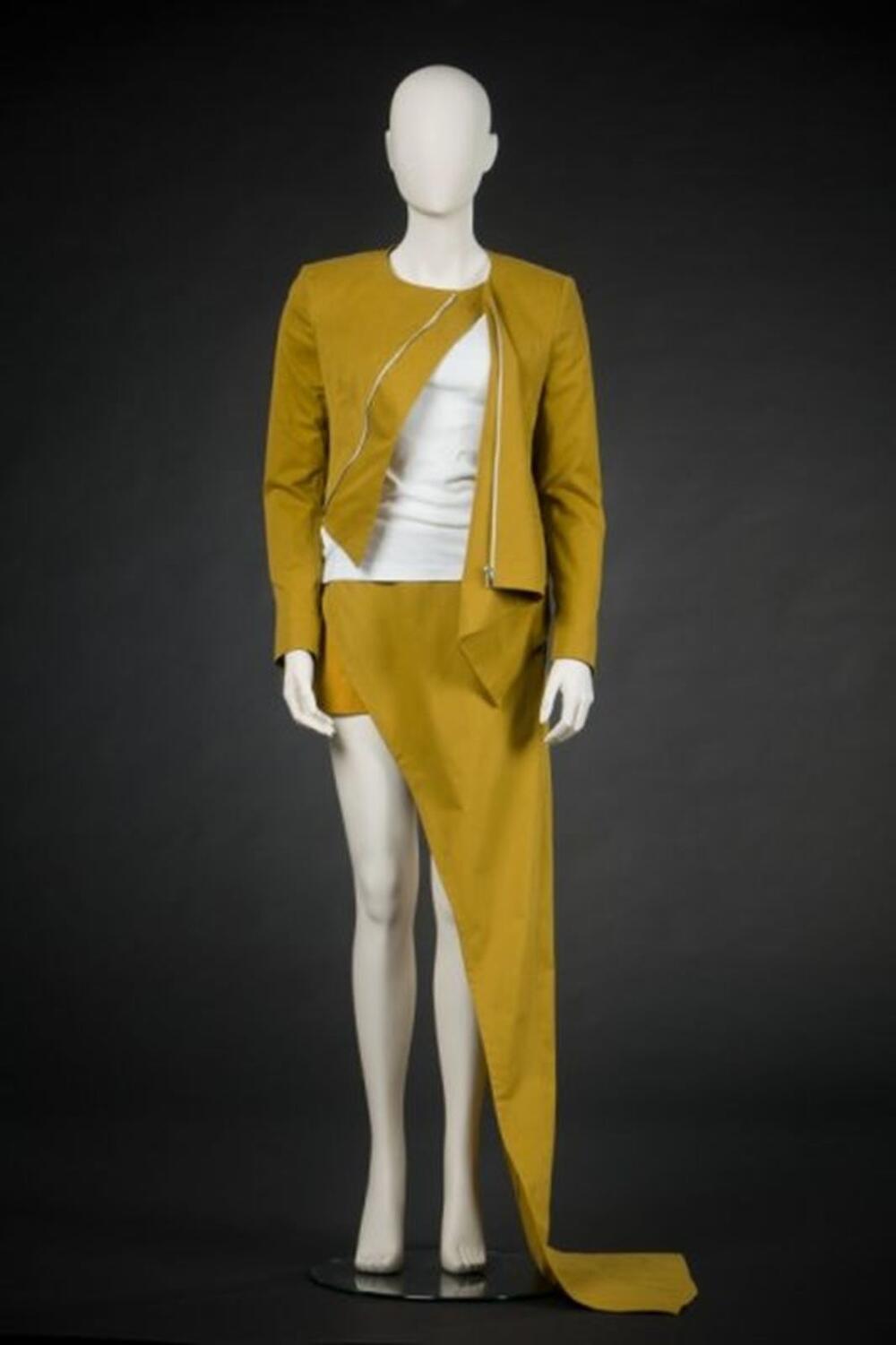 Ensemble bestaande uit vest met assymmetrische rits en rok met assymmetrie in okerkleur en witte t…