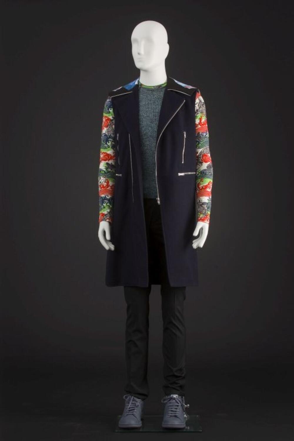 Ensemble bestaande uit gilet, trui, zwarte broek, grijze sneakers, T-shirt met koi-print en sokken
