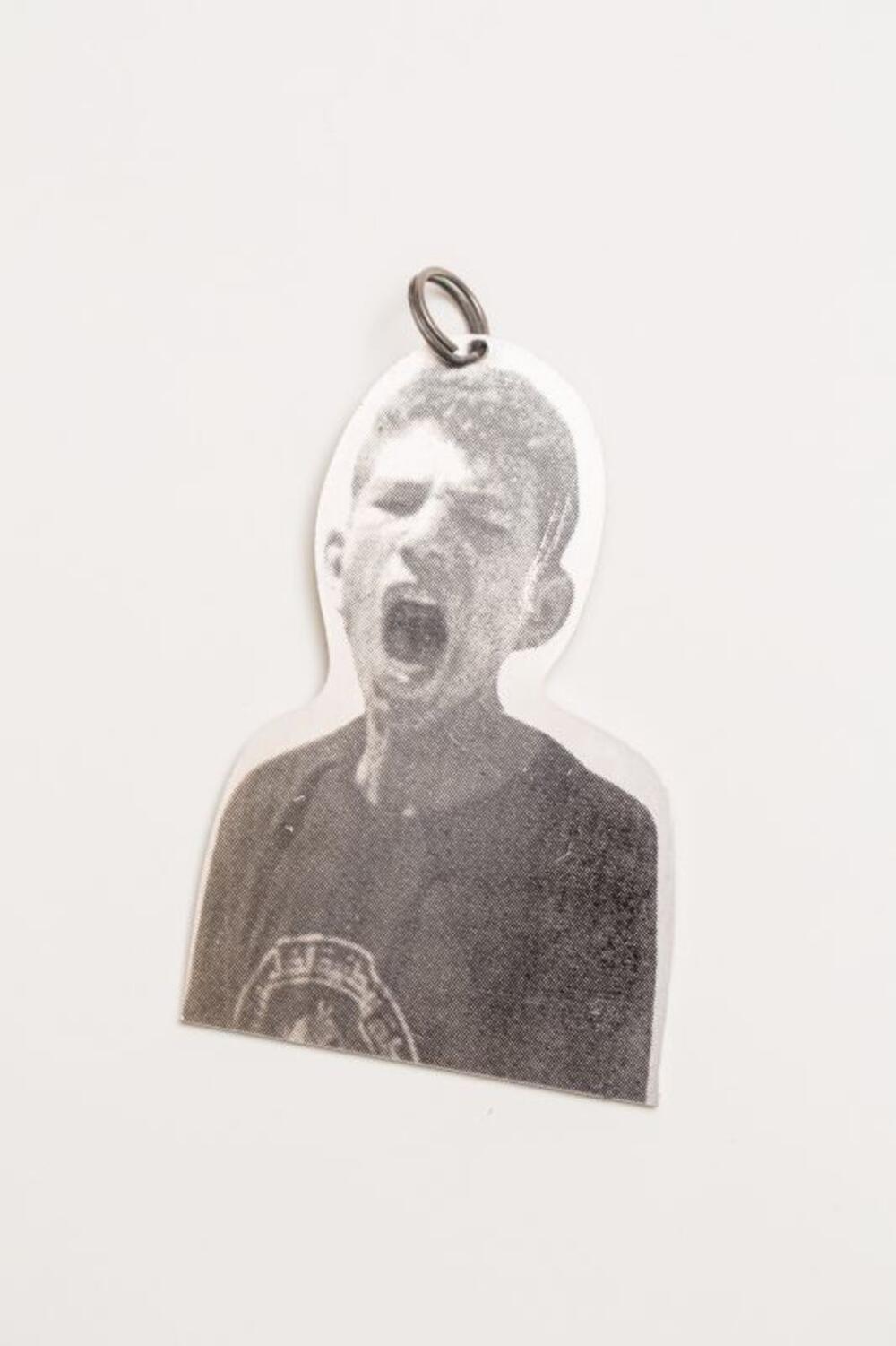Metalen hanger met bedrukking van een schreeuwende jongen