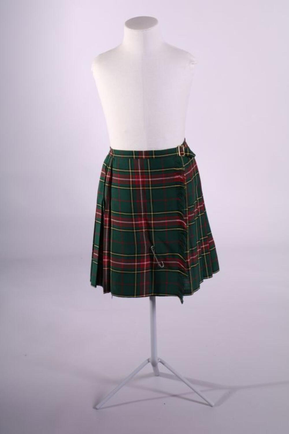 Groen, rood, geel en wit geruit jong meisjesrok (kiltmodel) met koperen gesp en grote speld