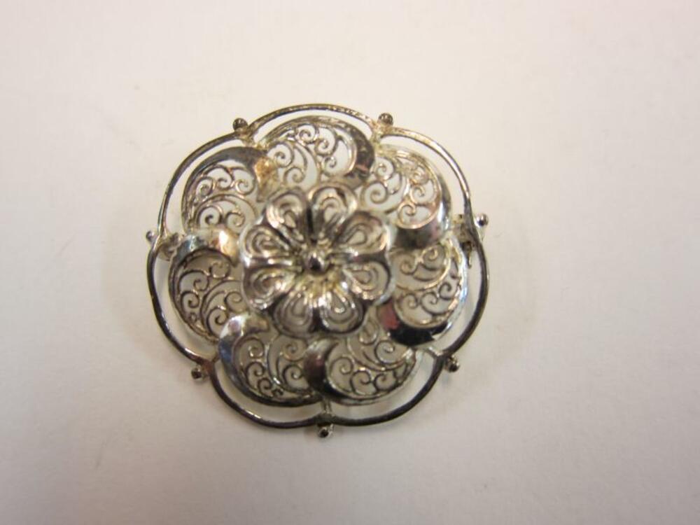 Broche in wit en zilverkleurig metaal in bloemvorm