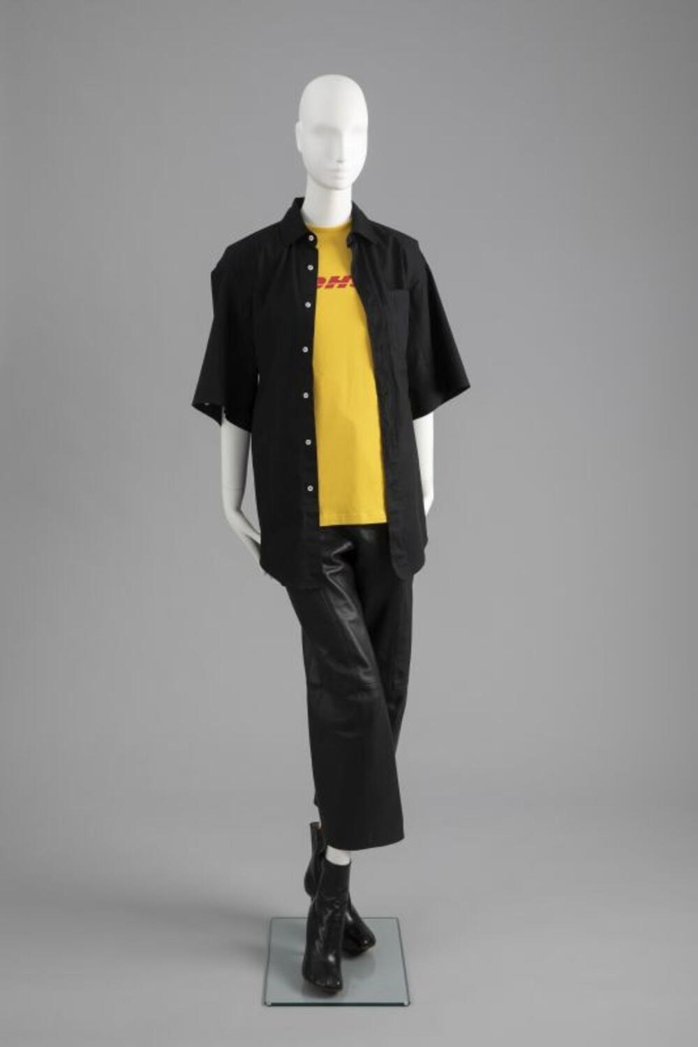 Ensemble bestaande uit overhemd, DHL T-shirt, leren broek en enkellaarzen