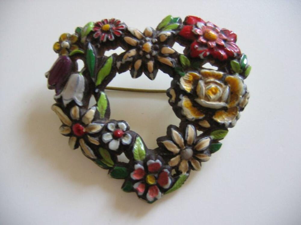 Hartvomige broche in koperkleurig metaal en veelkleurige plastic met bloemenversiering