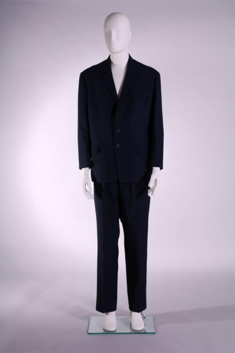 Pak in het donkerblauw bestaande uit jasje, broek, stropdas, handschoenenen in het grijs leer en…