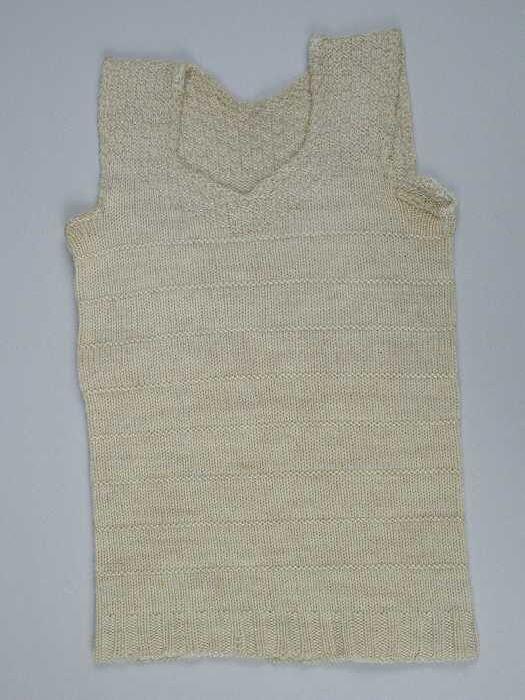 Kinderhemd of borstrok, gebreid van crèmekleurige wol in tricot- en reliëfsteken, blokjespatroon op…