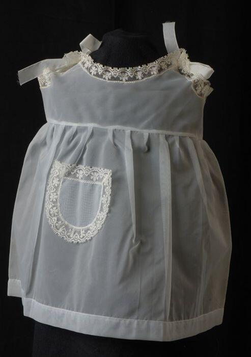 Babyjurk, mouwloos schortmodel van transparant lichtblauw nylonmet wit kant, 'Femifra', model …