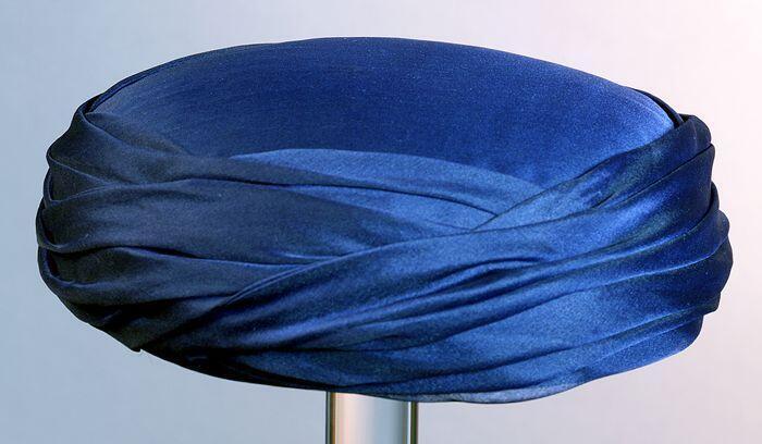 Ronde toque, donkerblauw satijn met organza draperie rondom
