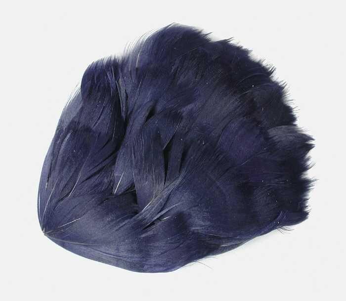 Veren hoedendecoratie of corsage, ovale papieren vorm beplakt met donkerblauwe veertjes
