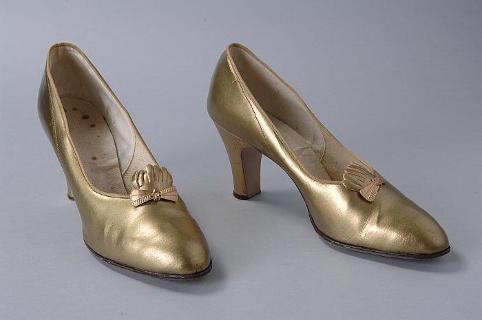 Goudkleurige pumps met metalen siergesp met waaiervormige decoratie, hoge cubahak