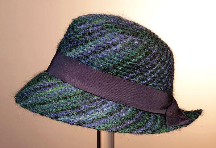 Dameshoed met blauw- en groentinen en donkerblauw ribslint, naar beneden afhangende rand met split…