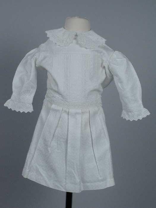Babyjurk of nachtjapon van wit katoen met ingeweven motief, broderieband op voorpand, hals en…