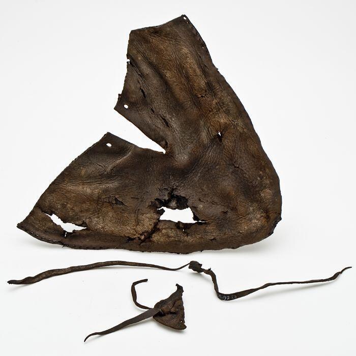 Voorblad van leren schoen, met inkeping in midden op blad en langs de randen naaigaten en met lip…