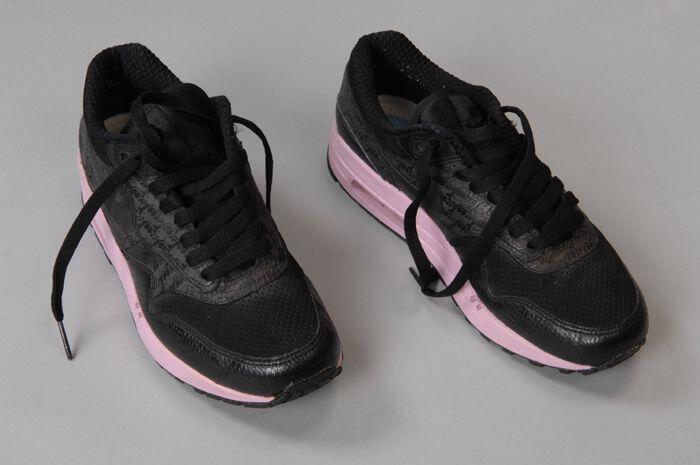Paar zwarte sportschoenen met roze zool van Nike