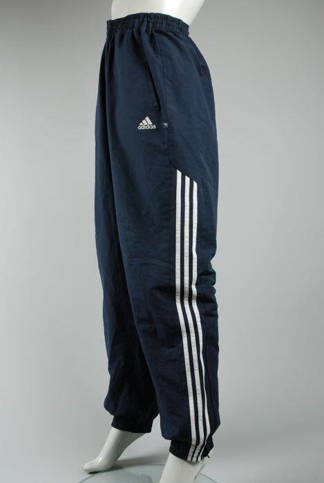 Donkerblauwe trainingsbroek van merk Adidas, witte strepen langs zijkant
