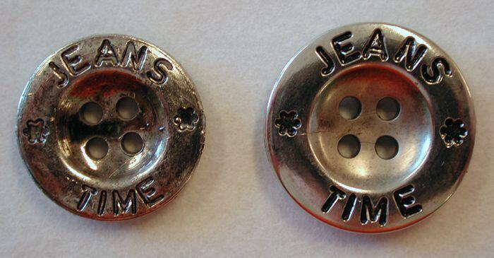 Twee zilverkleurige ronde knopen "JEANS TIME" van verschillend formaat
