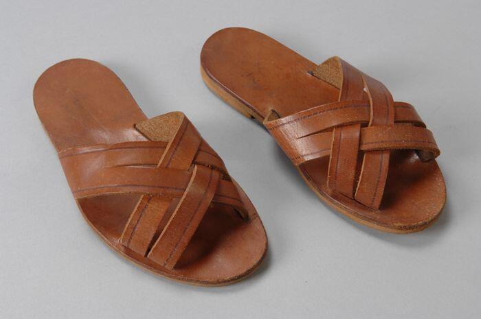 Bruine leren slippers met in elkaar gevlochten wreefbanden, platte zool, onderzijdevan kunststof