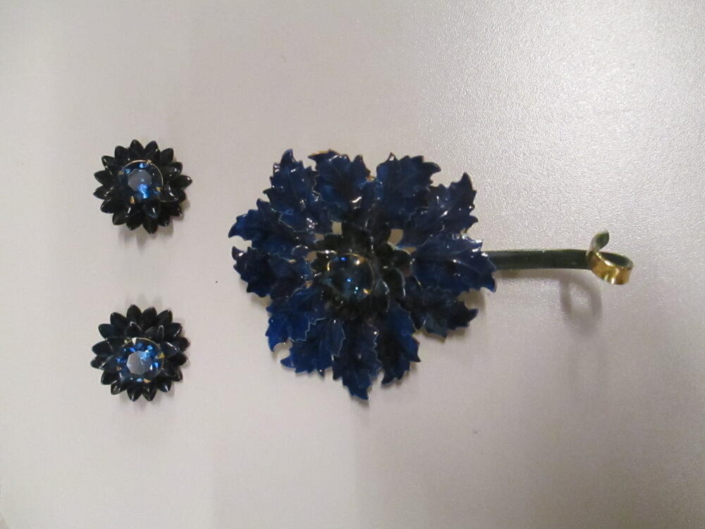Broche en oorclips, bloemvormig ontwerp met blauw geëmailleerde bladeren en hart van blauwe strass…