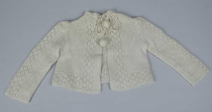 Babyvest gebreid van crèmekleurige dunne wol in tricotsteken en rechte banen ajour, koordje met…