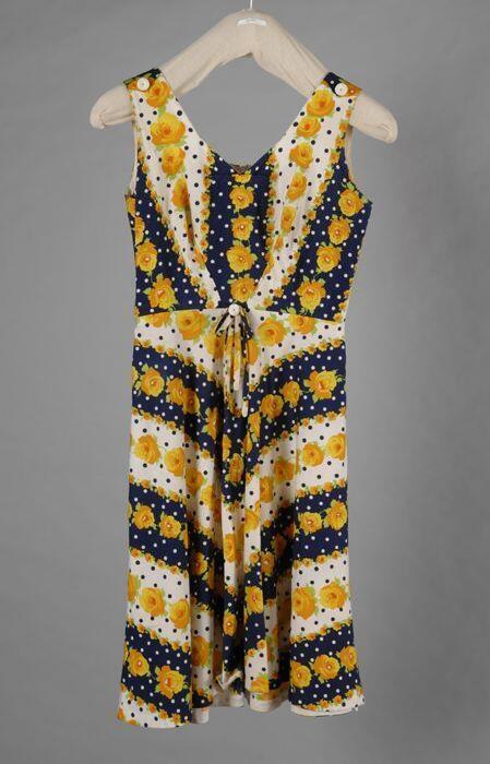 Mouwloze klokkende zomerjurk met diagonale blauwe en witte banen met geel-oranje rozen en blauw…