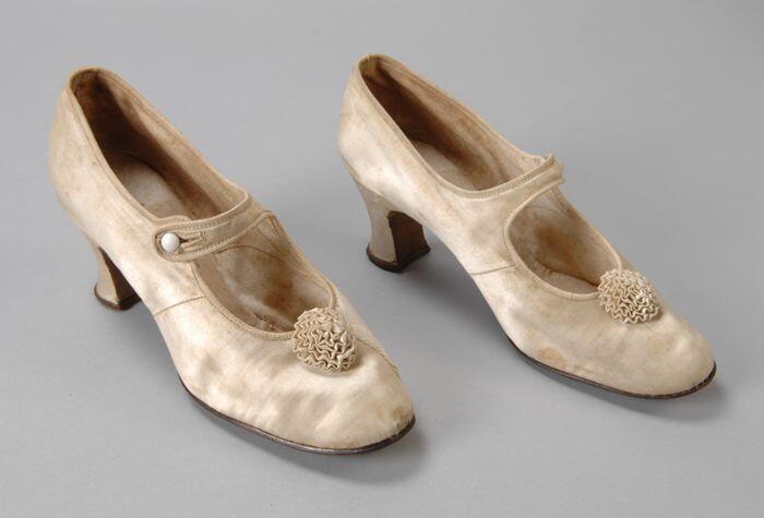 Roomwitte satijnen hakschoenen met rozet van geplooid satijn en wreefbandje met knoopsluiting