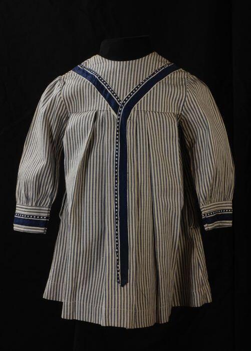 Jongensschort of morsschort van blauw-wit gestreepte katoen met lange mouwen en een blauwe Y…