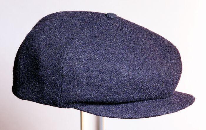 Jongenspet van donkerblauwe wolmet visgraatpatroon, met klep