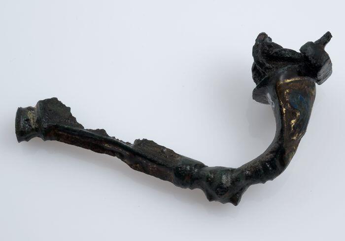 Bronzen fibula of mantelspeld met email versierd, deel van de naald resteert