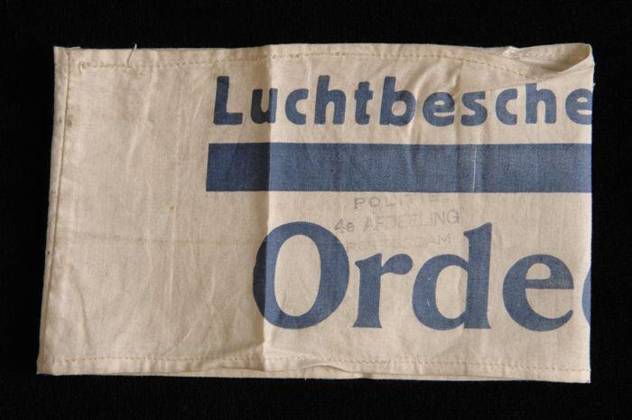 Mouwband, wit katoen met opdruk in donkerblauw, "Luchtbeschermingsdienst Ordedienst", twee stempels