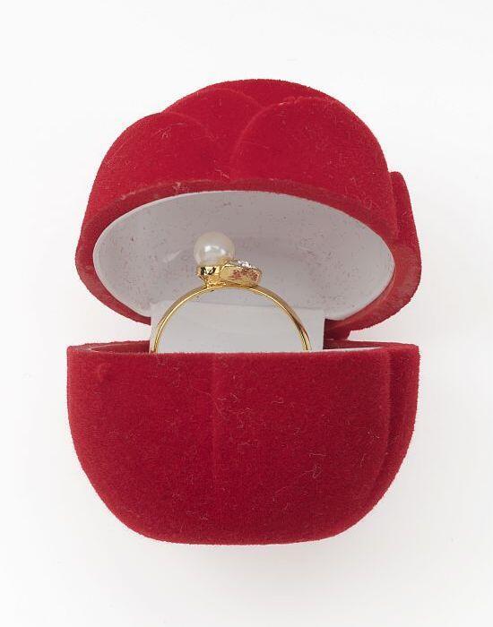 Goudkleurige metalen ring met nepparel in rood fluweelachtig doosje in de vorm van een rozenknop