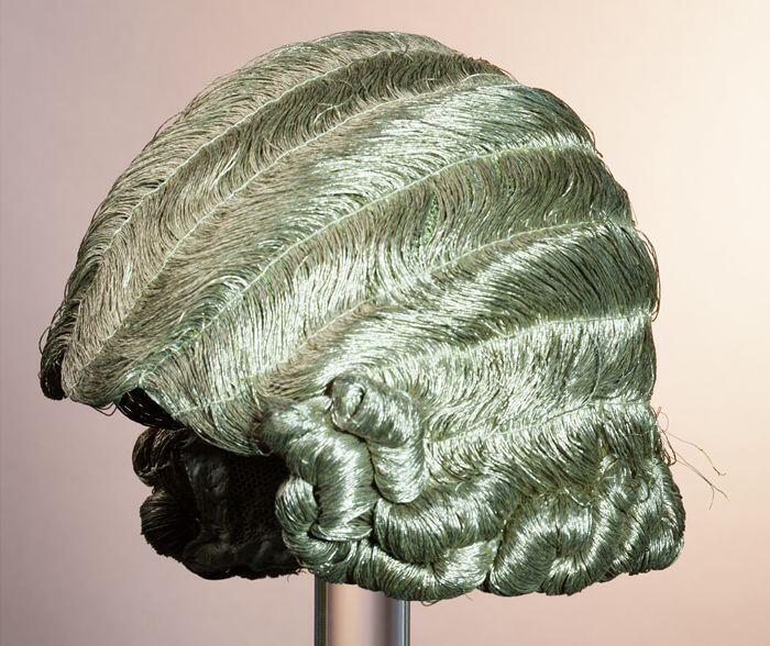 Pruik van goudkleurig draad met krullen aan de onderkant