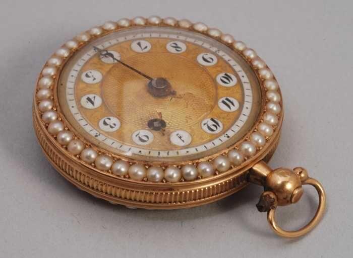 Gouden dameshorloge ofwel zakhorloge, voor- en achterzijdeafgezet met pareltjes, gouden wijzerplaat…