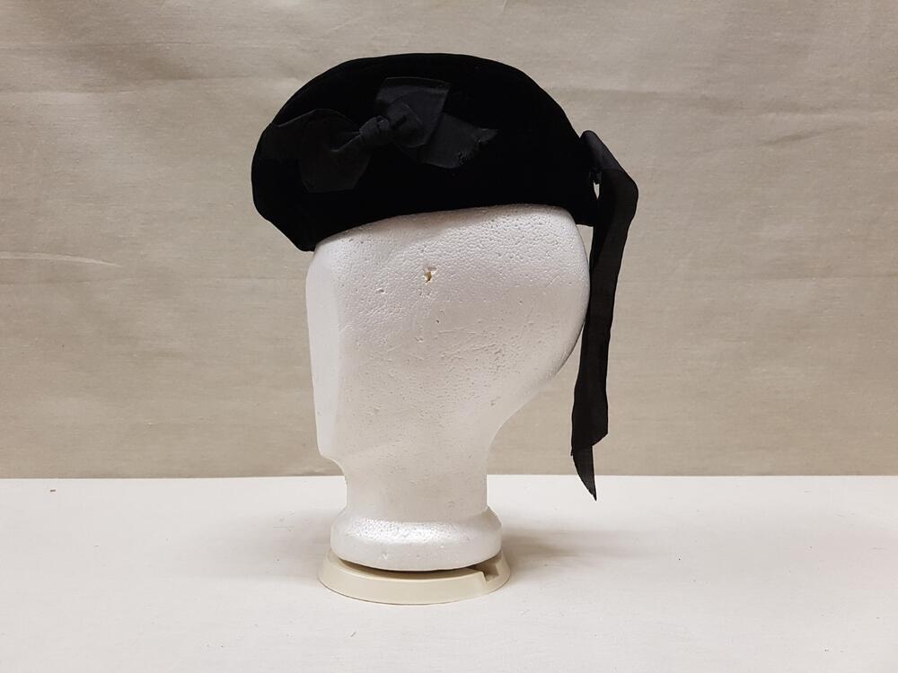 Baret of hoedje van zwart fluweel met zwart zijden lint van strik van idem