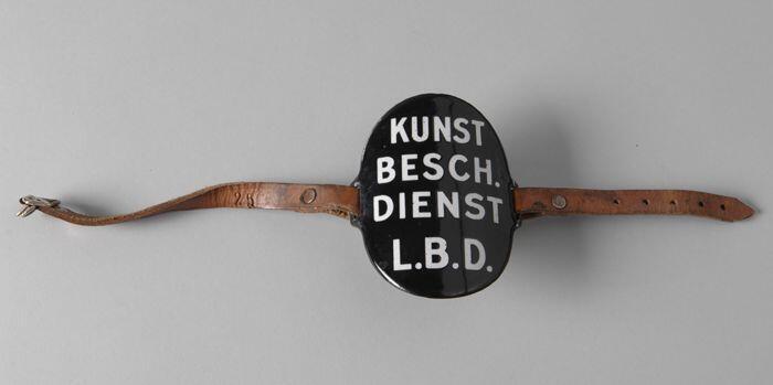 Ovaal zwart geëmailleerd armschildje met "KUNST / BESCH. / DIENST / L.B.D."