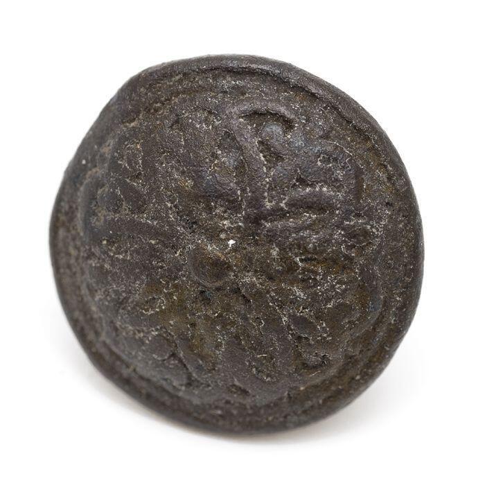 Metalen knoop met vast oog, in reliëf een bloemfiguur