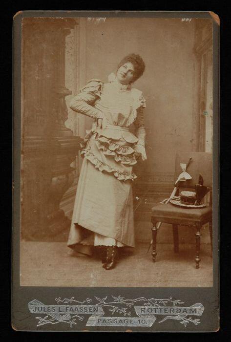 Foto van Marie van Eysden-Vink; dame naast stoel waarop een hoed ligt