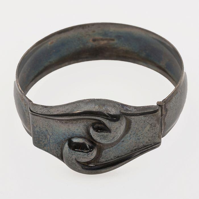 Armband van zilverkleurig metaal, ornament met voluut-achtige krullen