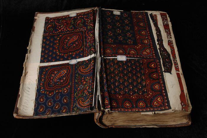 Groot dik stalenboek, gebonden bladzijde in leren band waarin stofstalen met batikdessin van de…