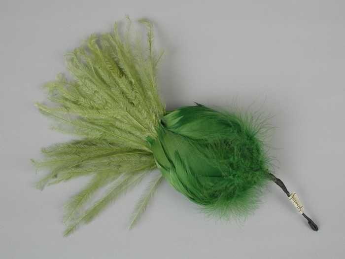 Veren hoedendecoratie of corsage, toefje groene veren met vanuit het midden een toefje groene…