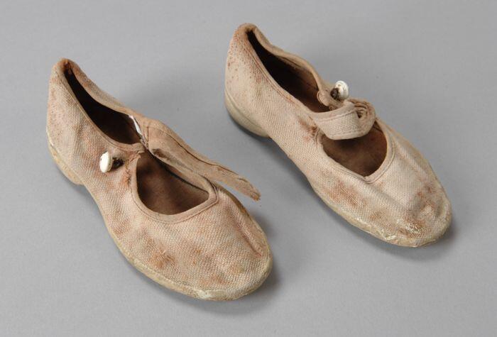 Kinderschoenen, klein formaat van wit canvas met crèmekleurig rubberzool