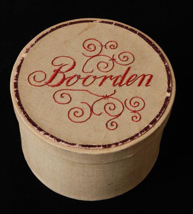 Ronde boordendoos met los deksel, karton overtrokken met beige katoenen bordeauxrood borduursel op…