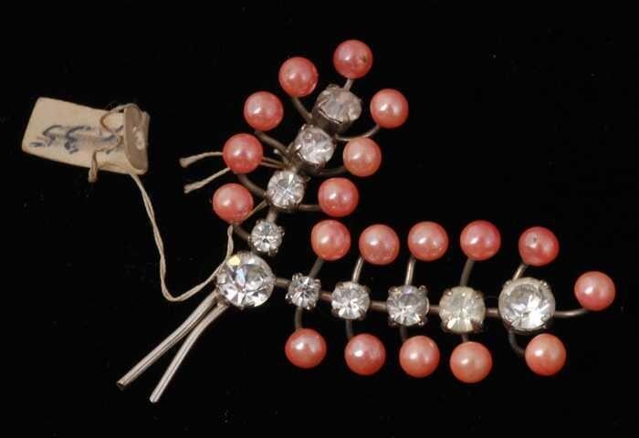Broche, sierspeld van zilverkleurig metaal, twee geveerde takkes met roze knopjes en kunstdiamanten…