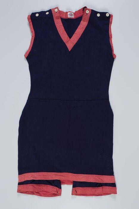 Badpak van donkerblauw tricot wolmet korte pijpen en rokachtige overslag, brede katoenen rode…