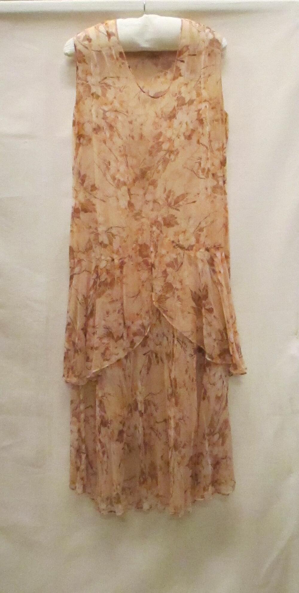 Avondjurk van zalmkleurige crêpe georgete (rayon), bedrukt met witte, bruine en oranje…